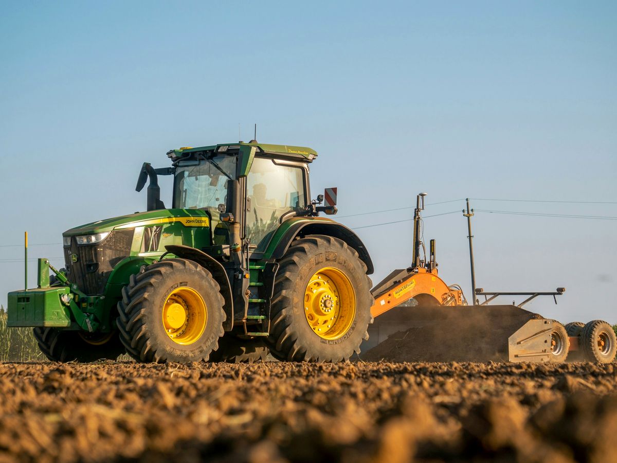 Tractor working a field at harvest time