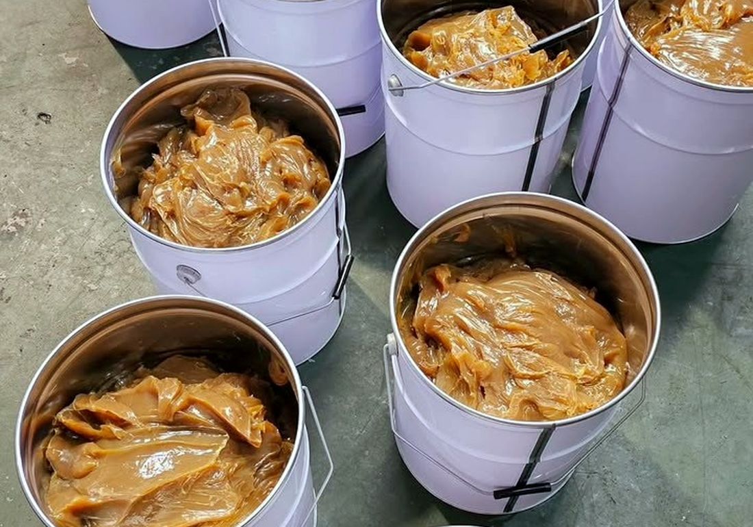 Open pails of industrial lubricating grease at a V&F Solutions facility
